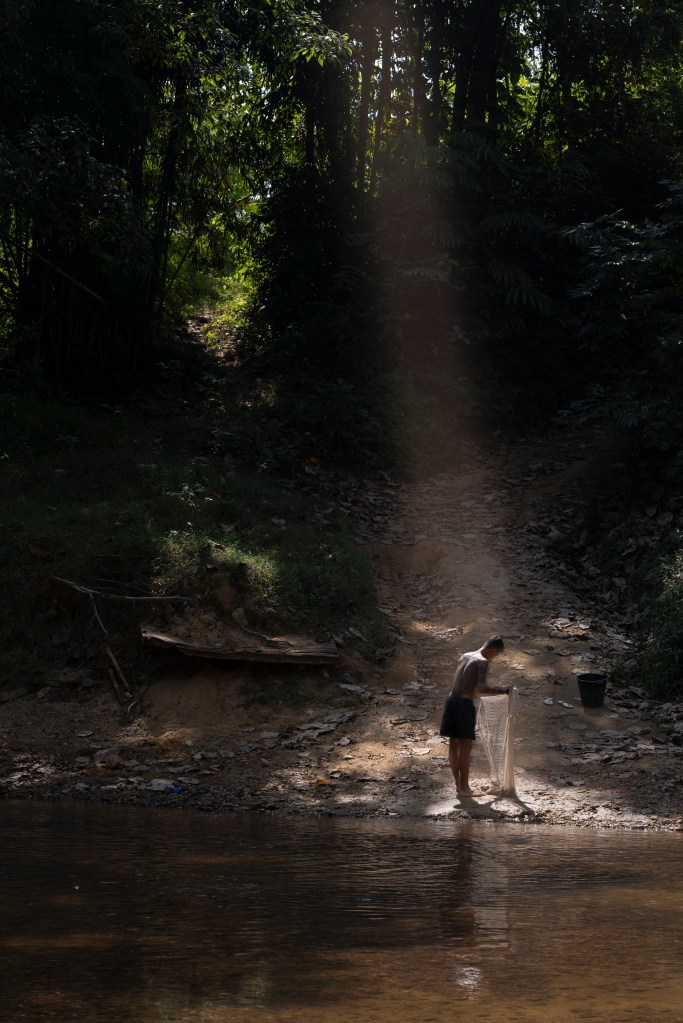 A lone Thai Fisherman prepares his net to fish by hand. 